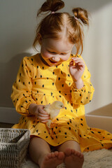 Girl in a yellow dress with a basket of chickens