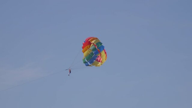 A man on a parachute follows the boat. 4k footage