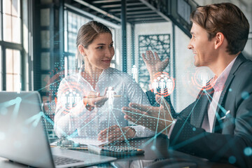 Businessman and businesswoman in formal wear working together looking for new employees to hire for international business consulting. HR, social media icons over modern panoramic office background