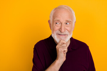 Photo of senior man curious minded plan look empty space think isolated over yellow color background