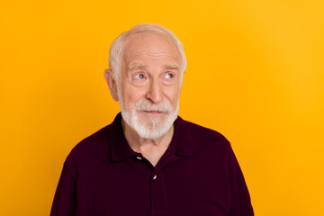 Photo of senior man thoughtful minded look empty space imagination isolated over yellow color...