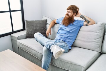 Obraz premium Young irish man smiling happy sitting on the sofa at home.