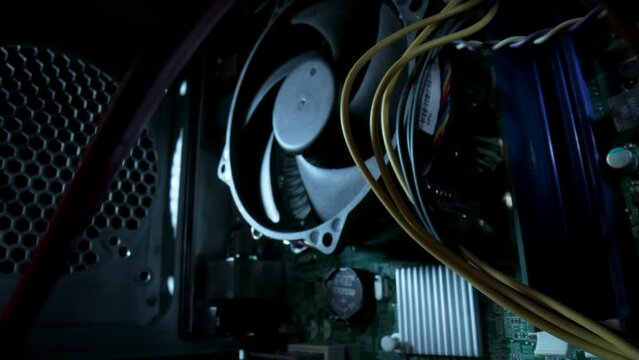 Camera movement inside an computer system unit. The camera zooms in on cooler. Shooting in motion, PC inside, wires and structure of computer. Close up computer components, electronic equipment Pc.