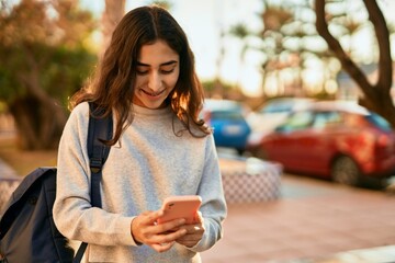 Young middle east student girl smiling happy using smartphone at the city.