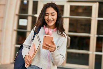 Young middle east student girl smiling happy using smartphone at the city.