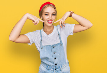 Obraz na płótnie Canvas Young caucasian girl wearing casual clothes smiling cheerful showing and pointing with fingers teeth and mouth. dental health concept.