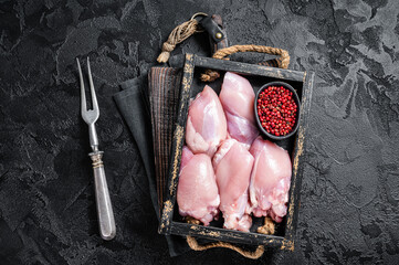 Raw Boneless and skinless Chicken leg thigh fillet with herbs. Black background. Top view