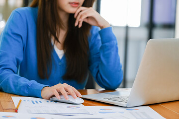 A female college student uses a computer to access the Internet for online learning.