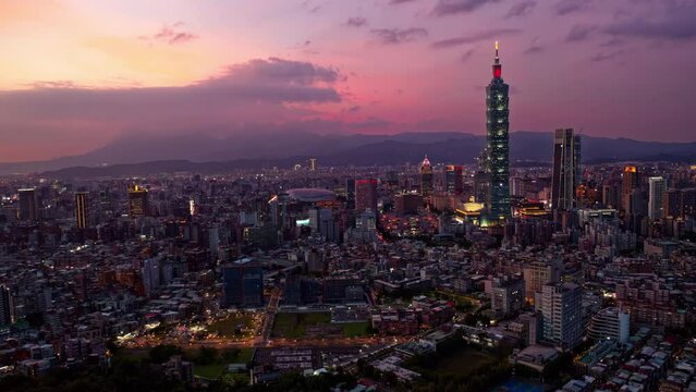 Aerial timelapse of Downtown Taipei at sunset, the vibrant capital city of Taiwan, with 101 Tower standing out amid modern skyscrapers in XinYi Commercial District and city lights dazzling at dusk
