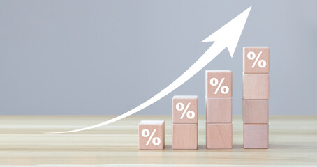 Interest rate financial and mortgage rates concept. Wooden blocks with Icon percentage symbol and arrow pointing up. The economy is improving. copy space