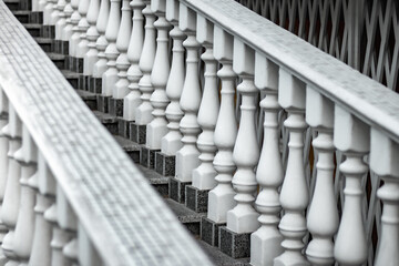 Obraz premium White staircase with balusters. Repetitive elements in architecture. Marble staircase in the restaurant