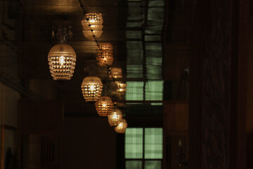 Perspective line of twilights at dark room. Row of hanging crystal lamp