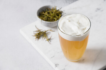 Chinese Cheese Tea with layer of creamy foam. Asian trendy beverage. Thai milk tea. Close up. Copy space.