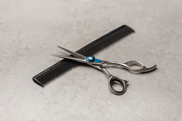 Stylish professional barber scissors, hair cutting shears on grey background. Hairdresser salon equipment concept, hairdressing set