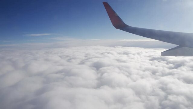 Airplane flight. Flying above the clouds. View from the window of the plane. Traveling by air