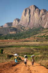 Fototapeta na wymiar Tsaronaro rock formation in Madagascar south, africa, with african women carrying food to the village, red sand, beautiful mountain know for adventure tourism and climbing, near the RN7