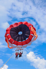 Parasailing under the blue sky at tropical islands. Holiday fun activities. Copy space for tourism and love relationship 