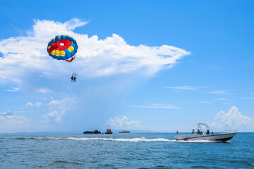 Parasailing above the ocean at tropical islands. Holiday fun activities. Copy space for tourism and love relationship 