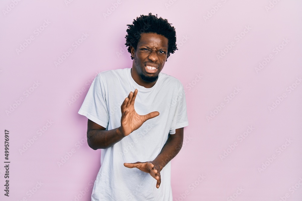 Poster young african american man wearing casual white t shirt disgusted expression, displeased and fearful