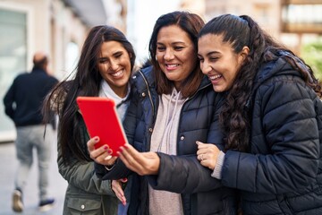 Three woman mother and daughters having video call at street