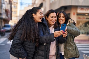 Three woman mother and daughters using smartphone at street