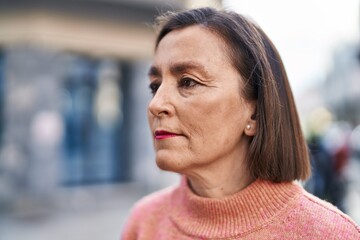 Middle age woman with relaxed expression standing at street