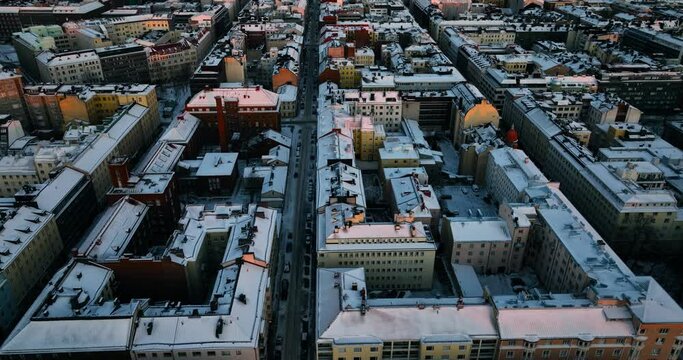 Aerial view overlooking snowy roofs and streets of Helsinki, Finland - tracking, drone shot