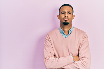 Young african american man wearing elegant clothes skeptic and nervous, disapproving expression on face with crossed arms. negative person.