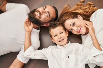 Fototapeta na wymiar Family smiling confident lying on floor at home
