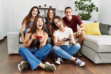 Group of young friends smiling happy playing video game at home.