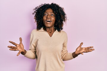 Young african american woman wearing casual clothes crazy and mad shouting and yelling with aggressive expression and arms raised. frustration concept.