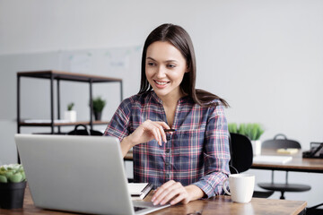 Young woman using laptop computer at office. Student girl working at class. Work or study from home, freelance, business, lifestyle concept