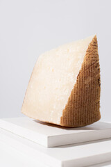 Trozo de queso manchego de oveja curado sobre una mesa blanca. Aperitivo español	