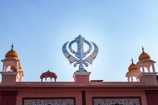 khanda sikh holy religious symbol at gurudwara entrance with bright blue sky