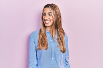 Fototapeta premium Beautiful hispanic woman wearing casual shirt looking to side, relax profile pose with natural face and confident smile.