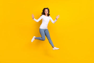 Fototapeta na wymiar Photo of shiny excited woman wear white shirt jumping high falling isolated yellow color background