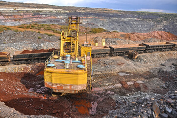 Loading of iron ore on the train in career. Loading overburden onto a train in a quarry