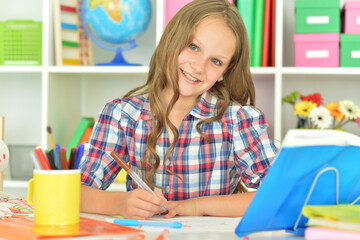 cute girl doing her home work at desk