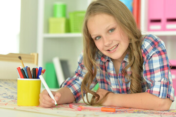 cute girl drawing at home at desk