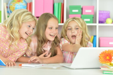 surprised cute girls with laptop on lesson