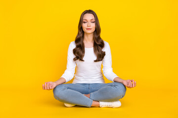 Photo of sweet peaceful woman wear white shirt practicing yoga sitting legs crossed isolated yellow color background