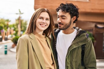 Man and woman smiling confident hugging each other at street