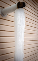 The exhaust pipe of the house heating has overgrown with icicles to the ground.