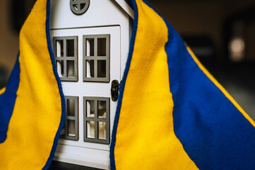 Ukrainian house with national yellow-blue flag. Shelter for homeless refugees from Ukraine to...