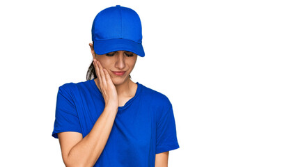 Young hispanic girl wearing delivery courier uniform touching mouth with hand with painful expression because of toothache or dental illness on teeth. dentist