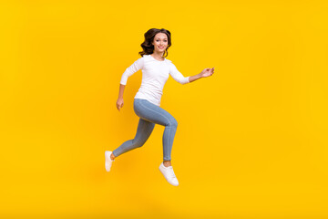 Fototapeta na wymiar Photo of adorable pretty woman wear white shirt jumping high running fast isolated yellow color background
