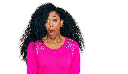 Middle age african american woman wearing casual clothes afraid and shocked with surprise expression, fear and excited face.