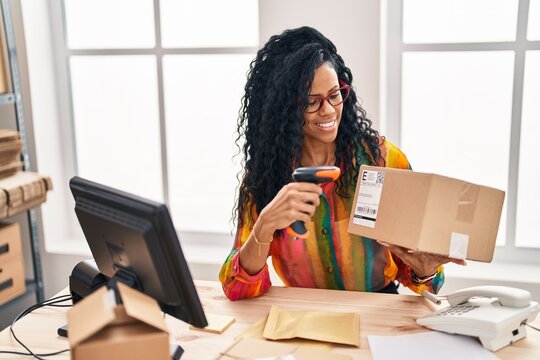 African american woman business worker scanning package at office