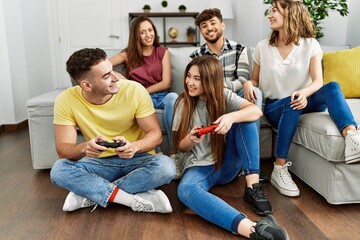 Fototapeta premium Group of young friends smiling happy playing video game at home.