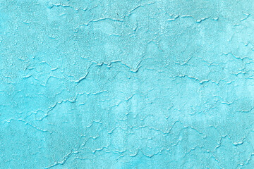 Texture of old painted azure wall with cracks. Rough blue background with scratches and paint smudges.